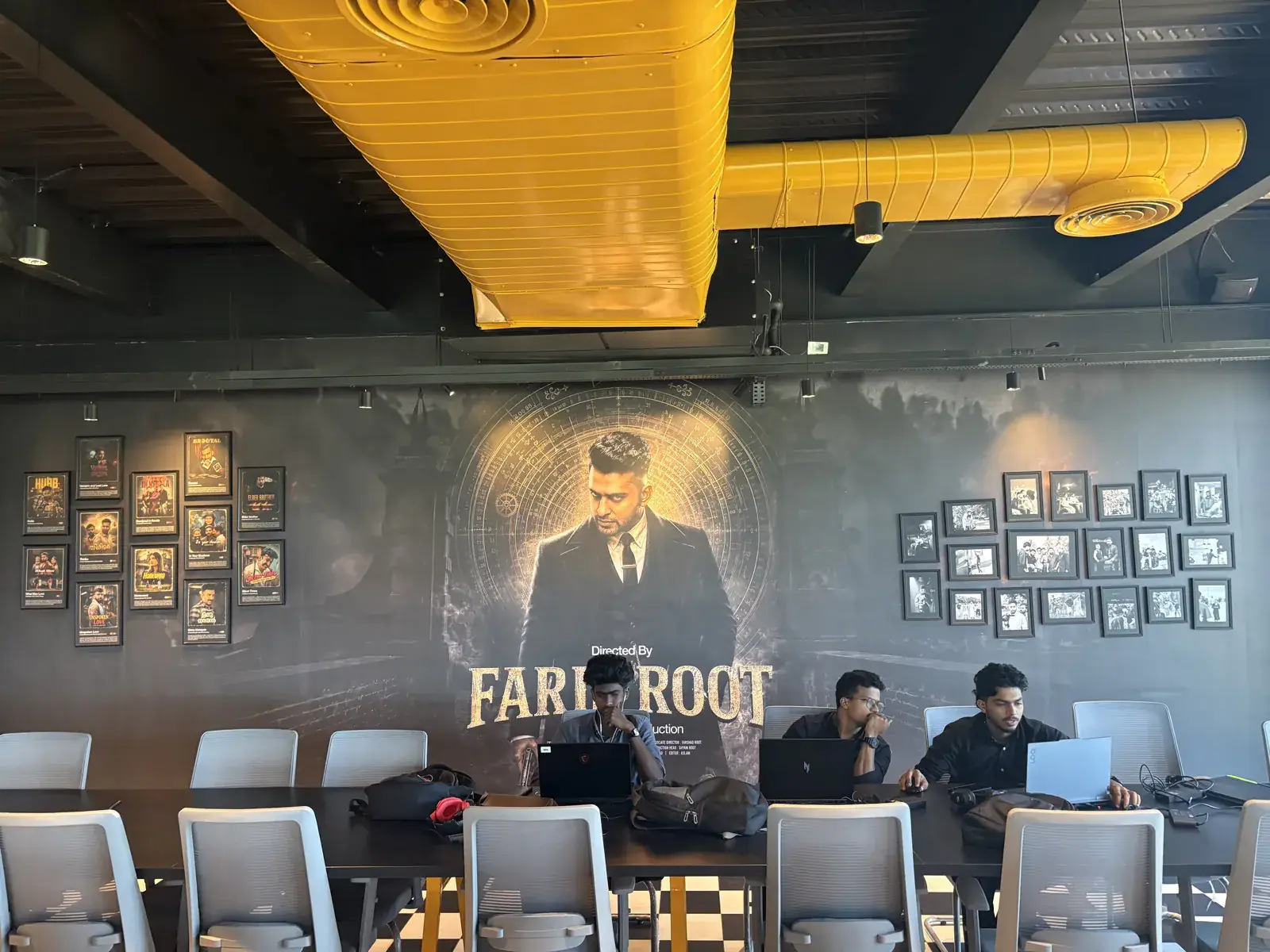 The Faris Root mural and framed portrait wall running the length of the Rootmedia floor