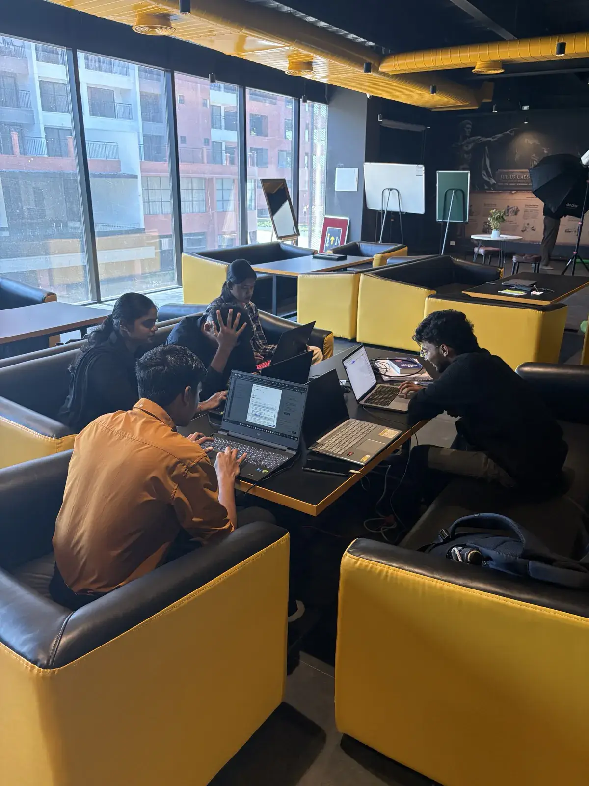 Four students working through a project together at a booth table