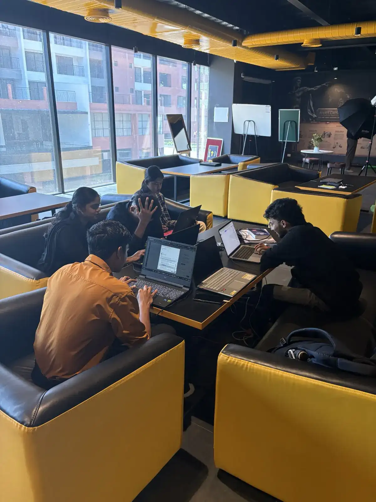 Four students working through a project together at a booth table