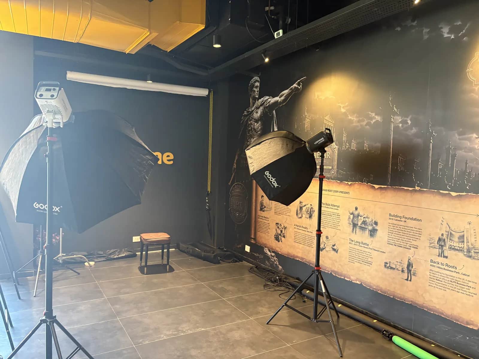 The in-house shoot floor at Rootmedia — Godox strobes, octabox and umbrella set against the backdrop wall