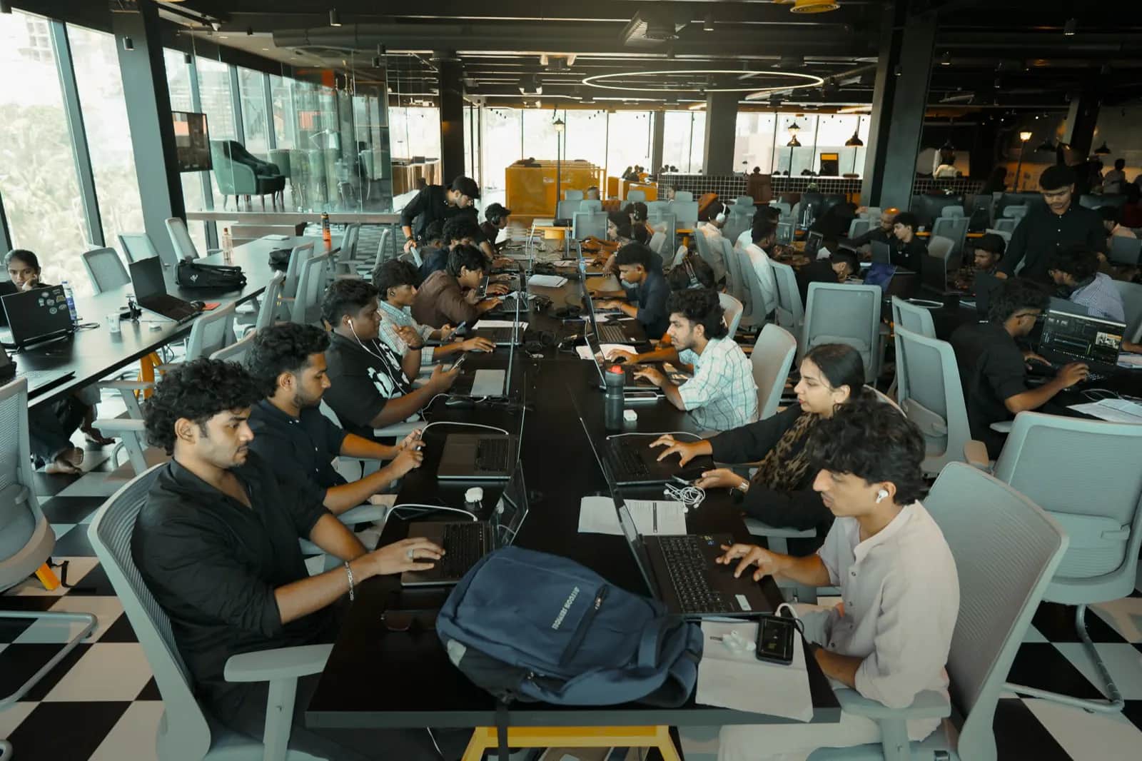 Students at laptops along a shared desk during a Rootmedia session