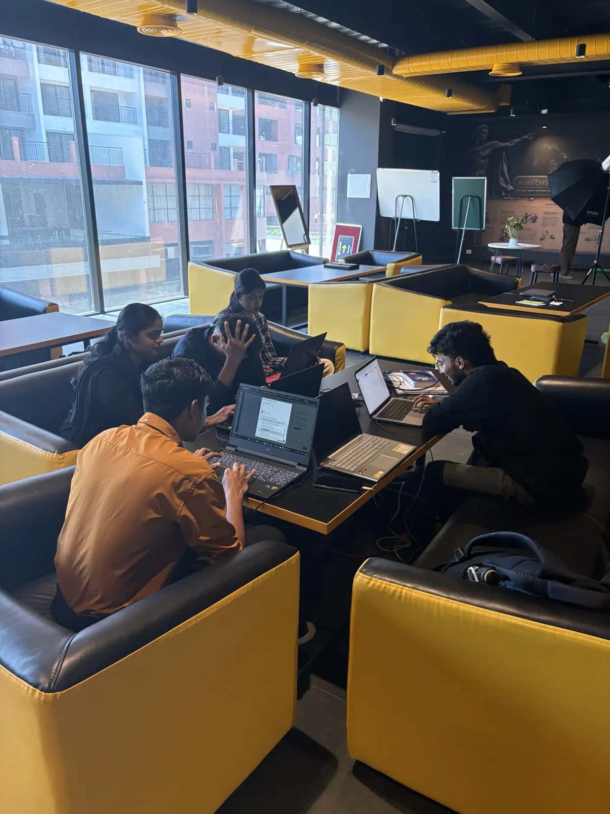 Four students working through a project together at a booth table
