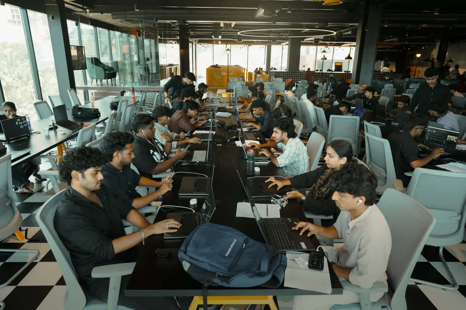 Students at laptops along a shared desk during a Rootmedia session